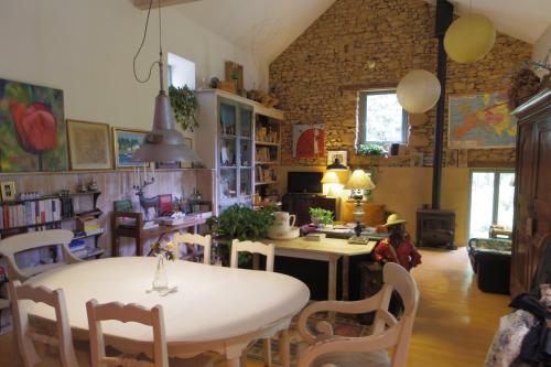 ein Wohnzimmer mit einem Tisch und Stühlen sowie eine Küche in der Unterkunft Gîte Les Truffières in Trémolat