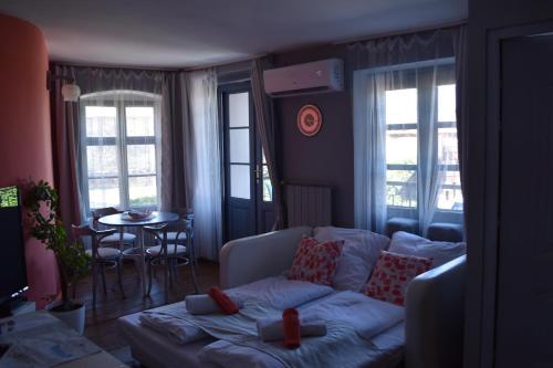 a living room with a white couch and a table at Főtér Apartmanház Szentendre in Szentendre