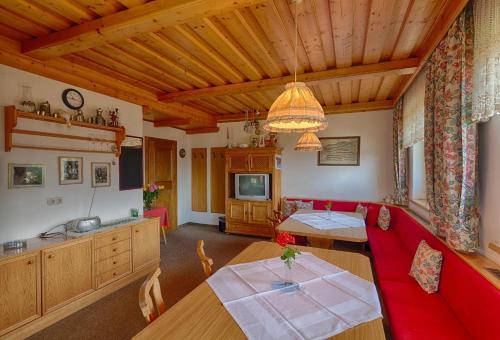ein Wohnzimmer mit einem roten Sofa und einem Tisch in der Unterkunft Landhaus Elisabeth in St. Johann im Pongau