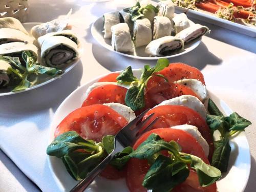 a table with plates of food with tomatoes and other foods at apartamenty kamienica in Puck