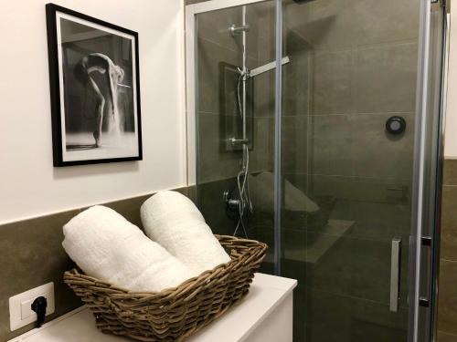 a bathroom with a shower and a basket of towels at Taliari Taormina Apartment in Taormina