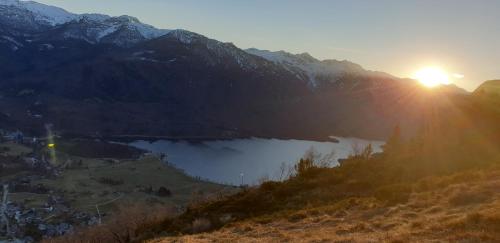 a view of a lake in the mountains with the sunset at APARTMA KAMNJE in Bohinj