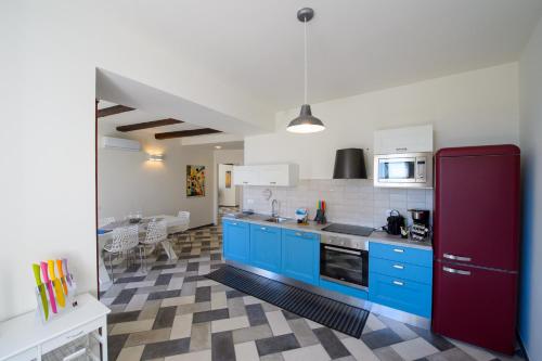 a kitchen with blue cabinets and a red refrigerator at Ranzoni 3 sub. 1 in Verbania