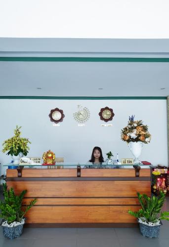 a woman is standing behind a counter in a salon at Mũi Dinh Hotel in Phan Rang