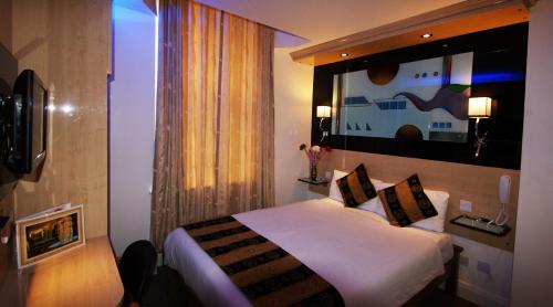 a hotel room with a bed and a painting on the wall at Westpoint Hotel in London