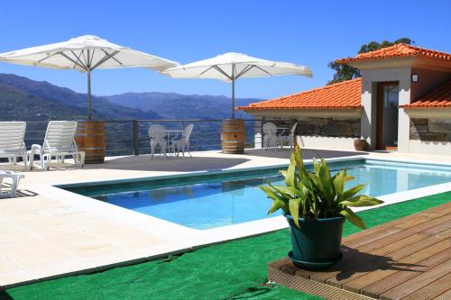 a swimming pool with a view of a house at Quinta da Bandeira - Casa de Férias no Douro in Mártir