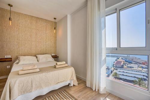 フエンヒロラにあるSur Suites Perla 6 - 2のベッドと大きな窓のある寝室