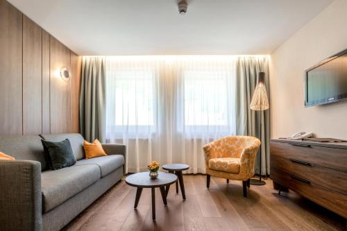 uma sala de estar com um sofá e uma cadeira em Hotel Garni Tannleger B&B em Brand