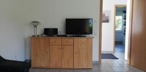 a flat screen tv sitting on top of a wooden cabinet at Ferienhaus Apfelblüte in Twielenfleth
