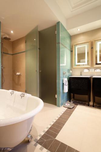 une salle de bain avec une baignoire, une douche et un lavabo dans l'établissement Majestic Apartments Champs Elysées, à Paris
