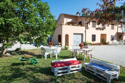 a yard with a table and chairs and a house at Cottoni Natural Space in Valtopina