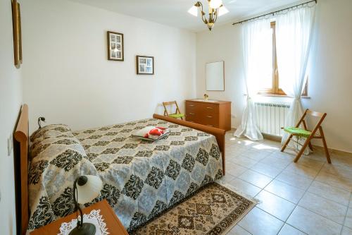 sypialnia z łóżkiem, komodą i oknem w obiekcie Cottoni Natural Space w mieście Valtopina