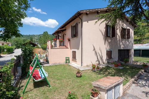 a small house with a yard with a swing at Cottoni Natural Space in Valtopina