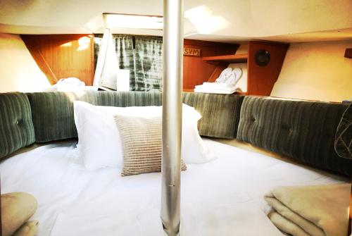 Frida Do-Minus sail boat في Minusio: غرفة مع سرير ووسائد على قارب