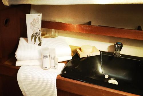 a bathroom with a black sink and towels at Frida Do-Minus sail boat in Minusio