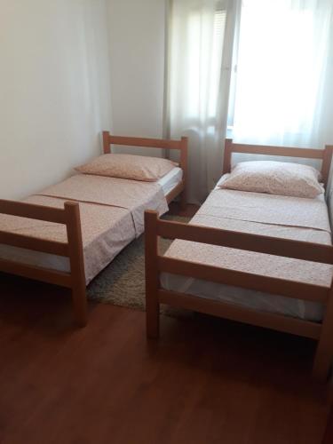 two twin beds in a room with a window at Apartman Anita in Livno