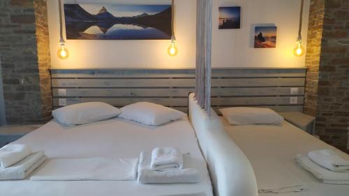 a white bed with two white towels on it at Anemos Sea View in Batsi