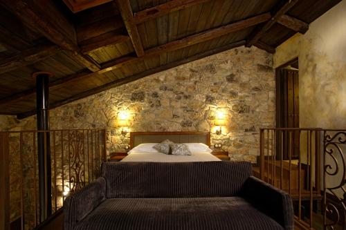 a bedroom with a bed and a couch in it at Hotel Rural & Spa Los Ánades in Abánades