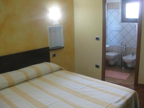a bedroom with a bed and a bathroom with a toilet at Agritursmo Montesalerno in Diamante