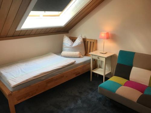 1 dormitorio con cama, lámpara y silla en Ella2, en Grömitz