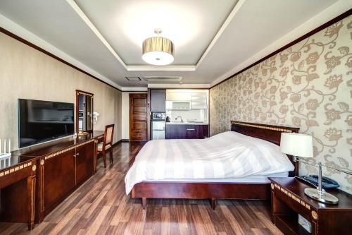 a bedroom with a bed and a flat screen tv at Geoje Oasis Hotel in Geoje 