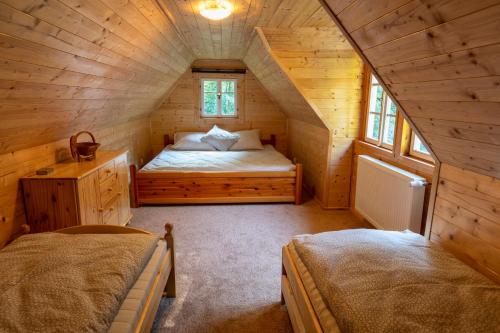 a bedroom with a bed in a wooden cabin at Chalupa 47 in Hřensko
