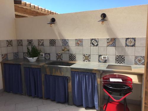 a kitchen with a sink and a red stool at Casa Vigna da Michela in Favignana