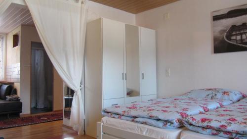1 dormitorio con 1 cama y armario blanco en Bahnhöfli Faulensee, en Faulensee