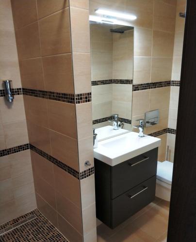 a bathroom with a sink and a mirror at Terrasun Apartments in Balatonszárszó