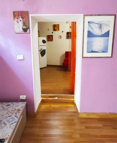 a room with a bed and a hallway with purple walls at Siracusa Ortigia by Duomo in Siracusa