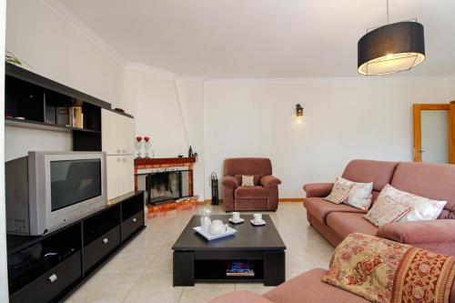 a living room with a couch and a tv at Senhora das Areias - Spacious Apt near the Cabedelo Beach in Viana do Castelo