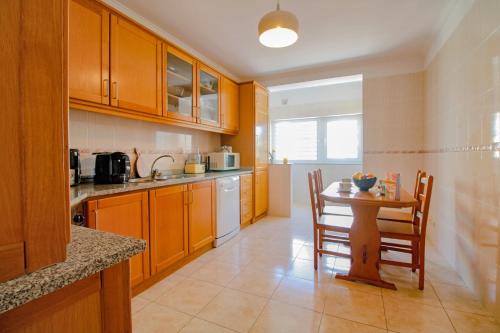 a kitchen with a table and chairs in it at Senhora das Areias - Spacious Apt near the Cabedelo Beach in Viana do Castelo