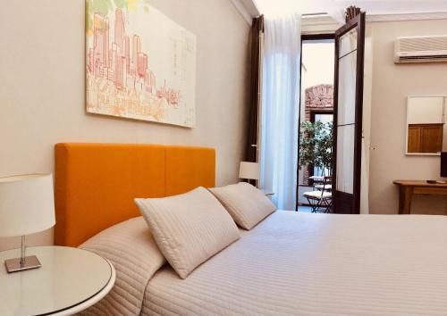a bedroom with a white bed and a table at Sangiuliano114 B&B in Catania