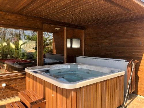 a large jacuzzi tub in a room with a window at Virág Vendégház in Hercegkút