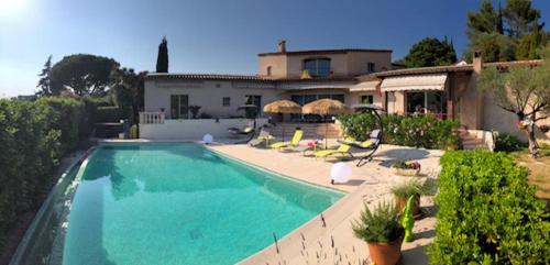 une grande piscine devant une maison dans l'établissement villa santa rita, à Auribeau-sur-Siagne