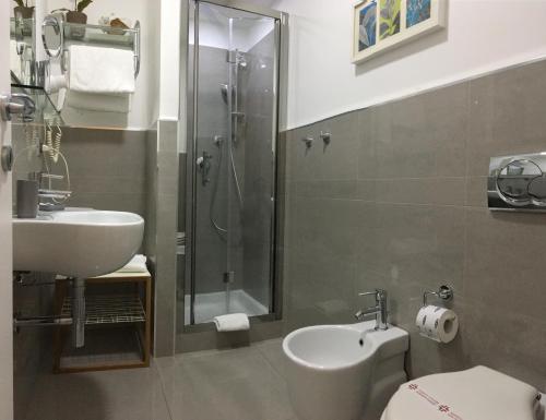 Un baño con ducha, lavabo e inodoro. en Sangiuliano114 B&B, en Catania