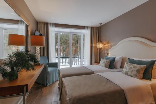 een hotelkamer met 2 bedden, een bureau en ramen bij Vania Rooms Hotel in Vladimir