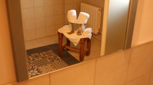 a bathroom with a chair with towels and a mirror at Castillo de Portilla Casa Rural in Portilla