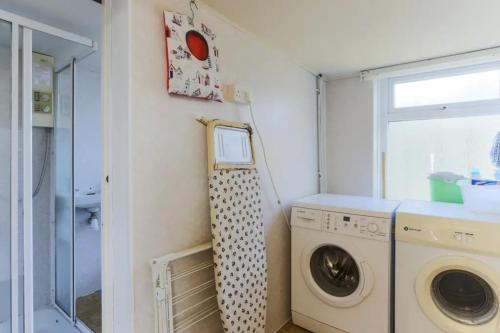a laundry room with a washer and dryer at Chy-an-Lowena in Crantock