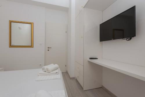a white bathroom with a tv on a white wall at Modern Apartman Pjero in Makarska