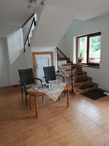 a living room with a table and chairs and stairs at Pensiunea Casa Transalpina in Şugag