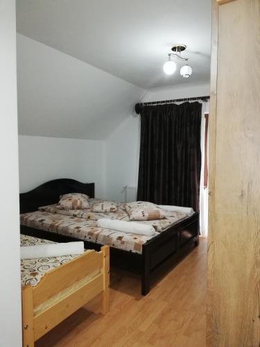 a bedroom with two beds and a window at Pensiunea Casa Transalpina in Şugag