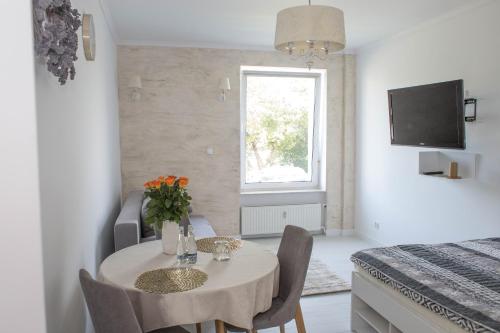 Pokój ze stołem, krzesłami i łóżkiem w obiekcie Apartamenty 19 we Władysławowie