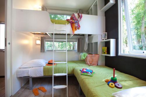 a small bedroom with a bunk bed and a bunk bedutenewayewayangering at Mobil home Domaine de Soulac in Soulac-sur-Mer