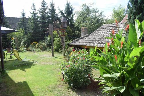 a garden with a bench and a table and some flowers at Bogdanówka in Supraśl
