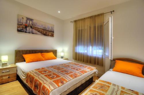 a bedroom with two beds and a window at Apartments Banicevic in Tivat