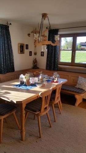 a wooden table with chairs in a living room at Woidhauserhof in Waakirchen