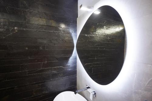 a bathroom with a toilet with a round mirror at Affittacamere Somnium in Sirolo