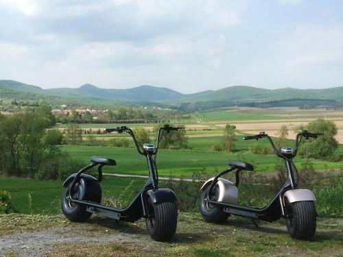 two electric scooters parked on the side of a hill at Virág Vendégház in Hercegkút