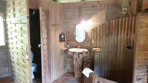 baño con lavabo en una pared de madera en Domaine de Robinson en Les Anses-dʼArlets